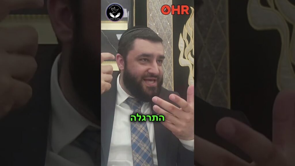 Bearded man in a suit speaking and gesturing with his hands, seated indoors; logos visible at the top (OHR) and a circular emblem in the background, with green Hebrew text across the bottom.